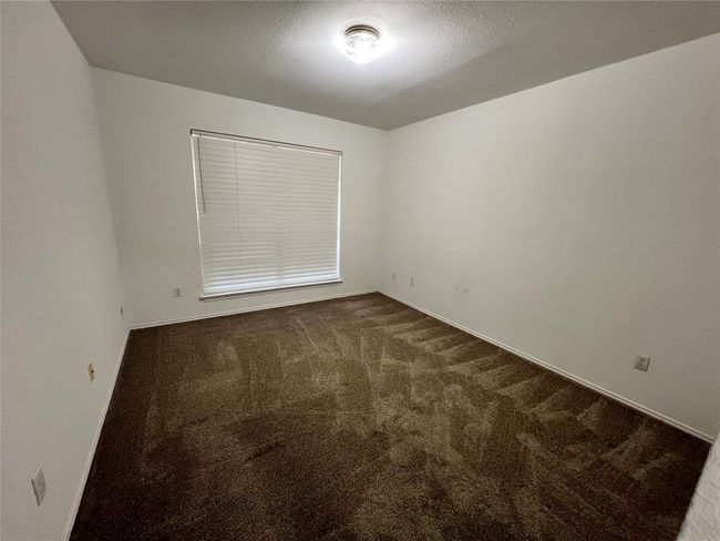 Spare room featuring carpet flooring, a textured ceiling, and baseboards | Image 11