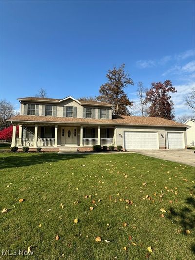 View of front of home featuring a front lawn, a porch, and a garage | Image 1