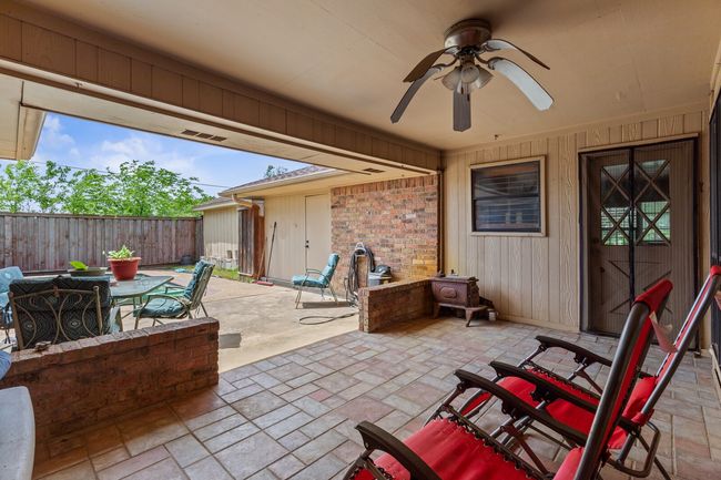 View of patio with outdoor dining area, fence, and ceiling fan | Image 30