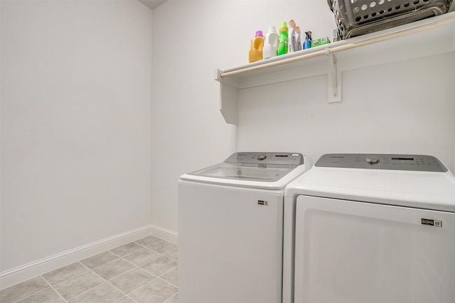 Laundry area featuring washing machine and dryer and baseboards | Image 35