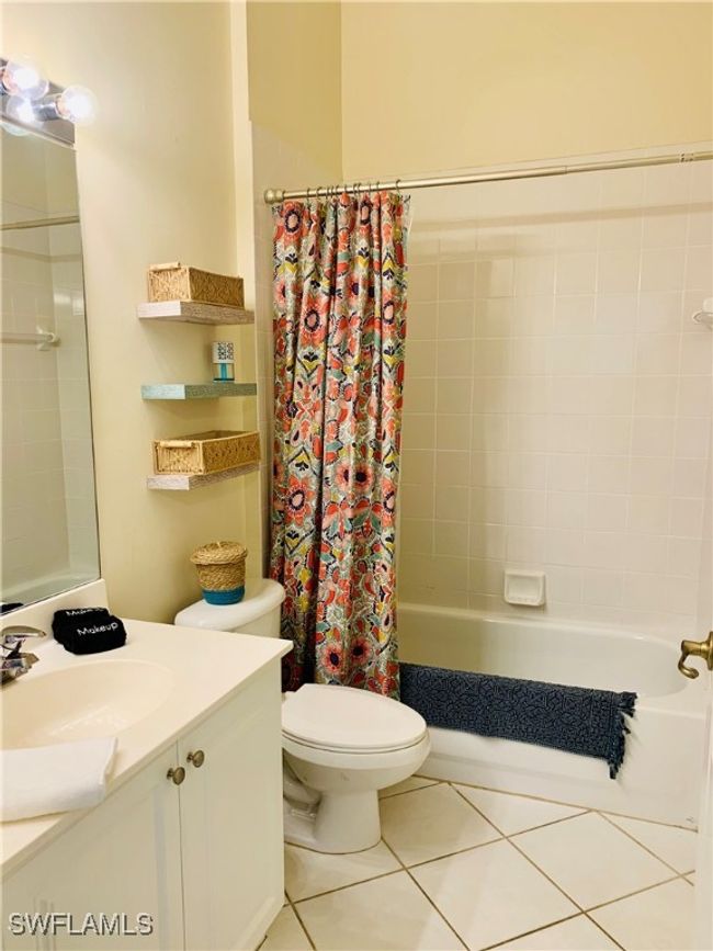 Full bath featuring toilet, shower / bath combo, tile patterned flooring, and vanity | Image 4