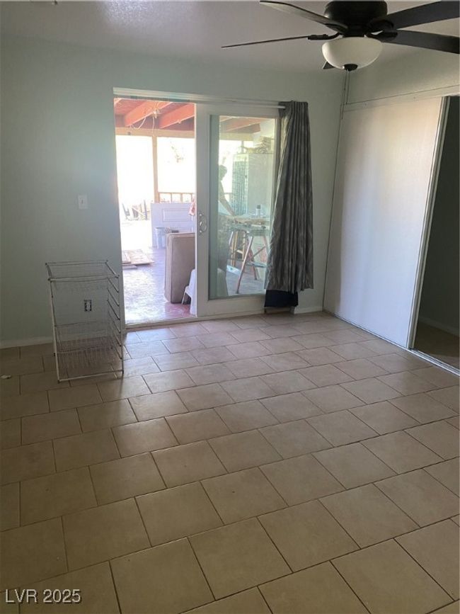 Spare room with a ceiling fan, tile patterned flooring, and baseboards | Image 18