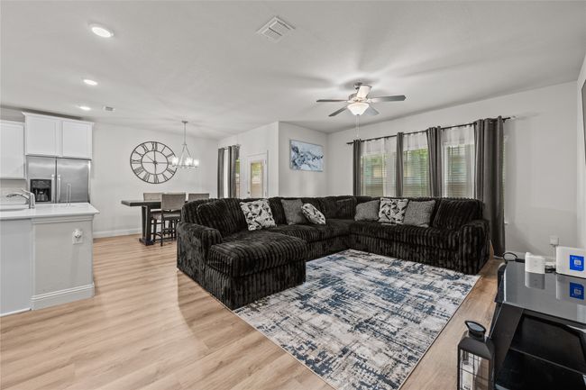 Living room featuring a chandelier, a ceiling fan, light wood-style floors, recessed lighting, and baseboards | Image 9