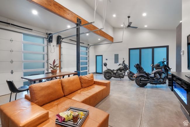 Living area featuring electric panel, finished concrete floors, ceiling fan, recessed lighting, and high vaulted ceiling | Image 77