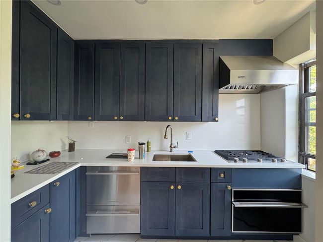 Kitchen with range hood, light countertops, appliances with stainless steel finishes, and a warming drawer | Image 5