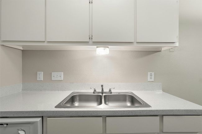 Kitchen with dishwasher, a sink, white cabinetry, and light countertops | Image 13