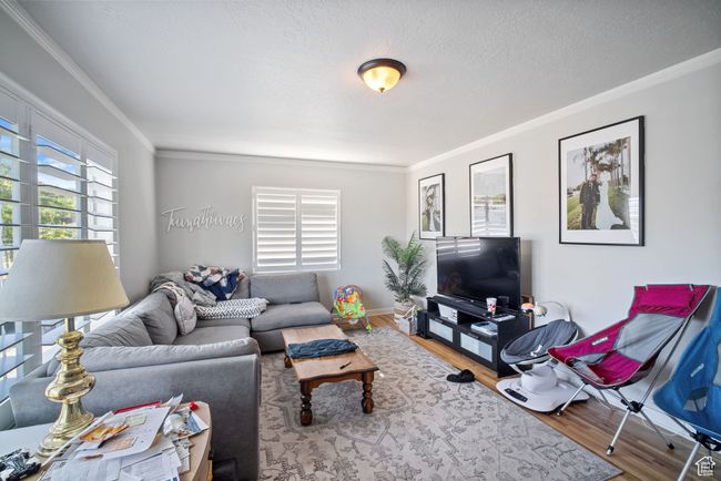 Living room featuring crown molding, wood finished floors, and baseboards | Image 8