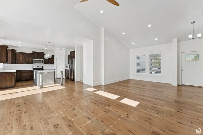 Unfurnished living room with recessed lighting, light wood finished floors, ceiling fan, and high vaulted ceiling | Image 6