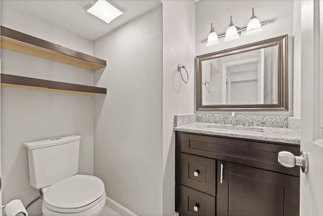 Bathroom with a textured wall and vanity | Image 12