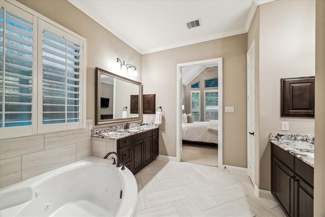 Primary ensuite features tile laid in a chevron pattern. | Image 16