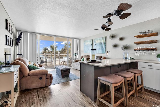 Kitchen with open floor plan, open shelves, a wall of windows, a ceiling fan, and wood finished floors | Image 21