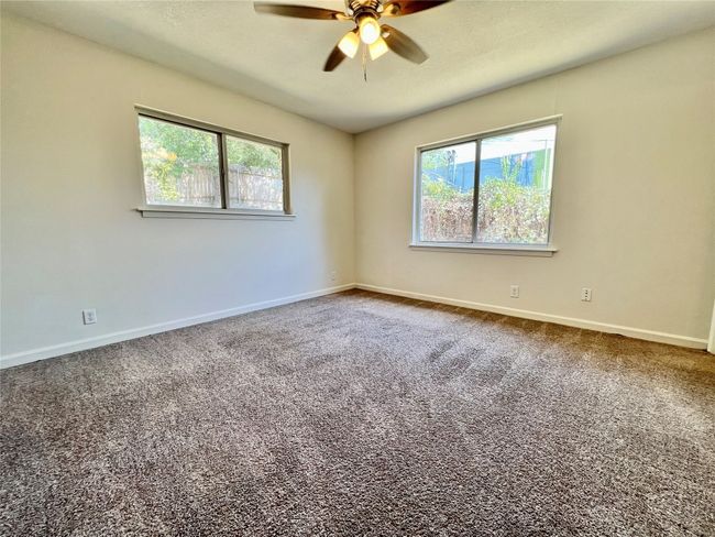 Unfurnished room with ceiling fan, baseboards, and dark carpet | Image 19