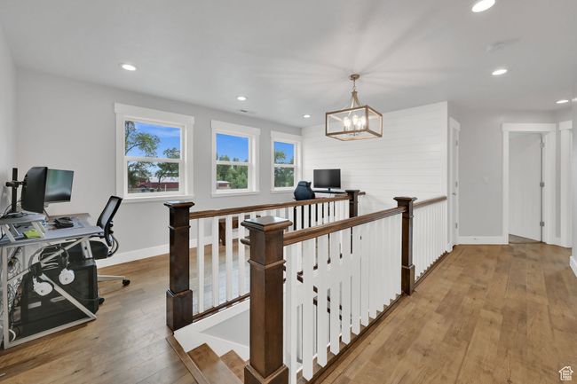 Hallway with an upstairs landing, light wood-style flooring, a desk, recessed lighting, and a chandelier | Image 31