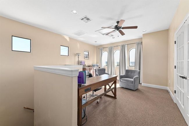 Carpeted office with baseboards, ceiling fan, and visible vents | Image 16