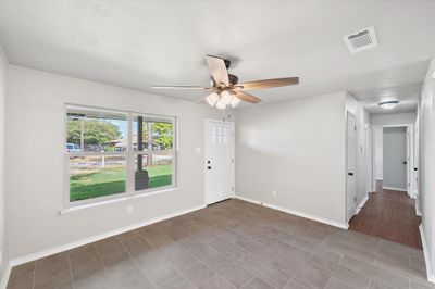 Living room with wood-style tile floors and ceiling fan | Image 3