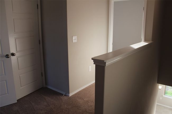 Hallway featuring carpet floors, baseboards, and an upstairs landing | Image 11