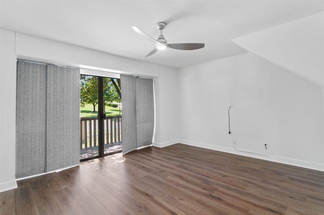 Living area with brand new flooring, sliding doors to patio and custom ceiling fan. | Image 7
