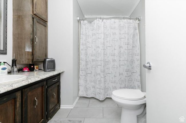 Bathroom featuring toilet, tile patterned floors, a shower with shower curtain, and vanity | Image 26