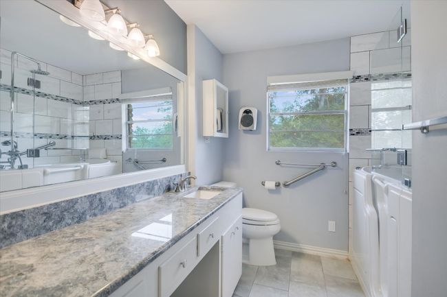 Updated remodeled hall bathroom features a granite counter top and special needs walk in tub/shower. | Image 26