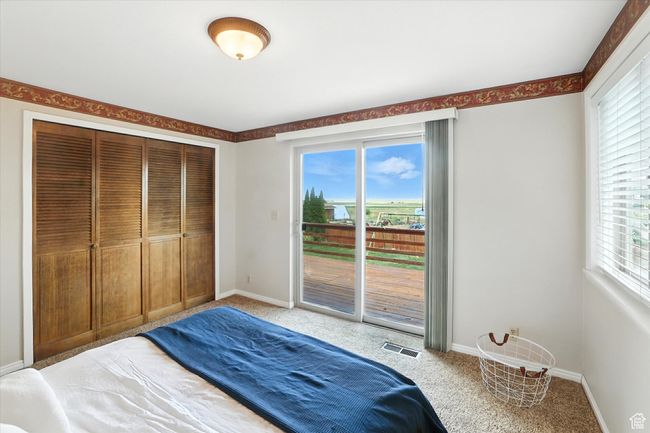 Primary bedroom featuring access to outside, light carpet, and a closet | Image 15