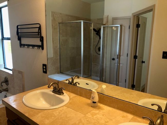 Full bathroom featuring plenty of natural light, double vanity, a stall shower, and a tub to relax in | Image 7