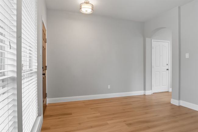 Empty room featuring light wood-style flooring, baseboards, and arched walkways | Image 24
