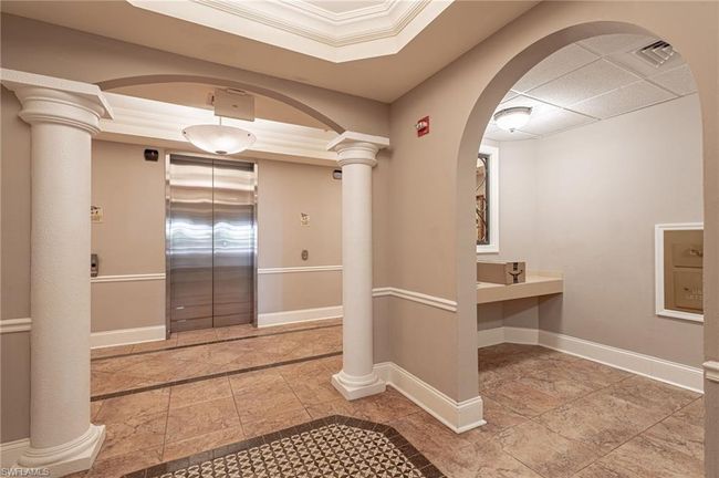 Bathroom with elevator, tile patterned floors, and decorative columns | Image 6