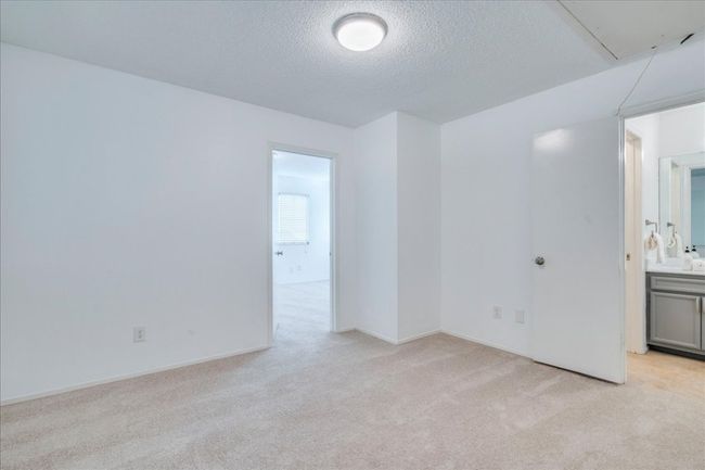 Spare room featuring light colored carpet, attic access, a textured ceiling, and baseboards | Image 23