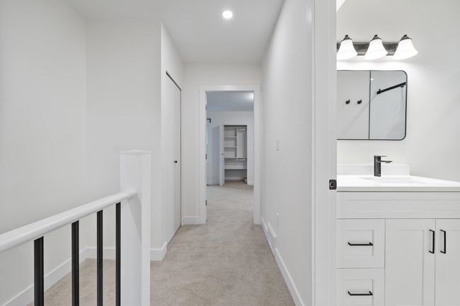 Hall featuring baseboards, light carpet, an upstairs landing, recessed lighting, and a sink | Image 11