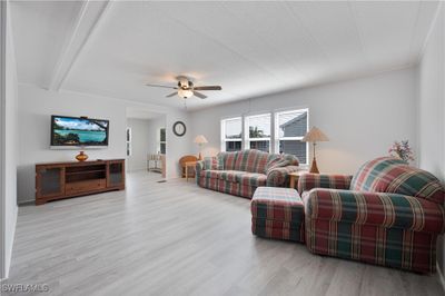 Living room featuring light hardwood / wood-style floors, a textured ceiling, and ceiling fan | Image 3