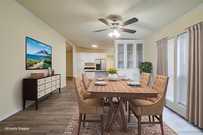 Dining space with ornamental molding, a ceiling fan, baseboards, and dark wood-type flooring | Image 10