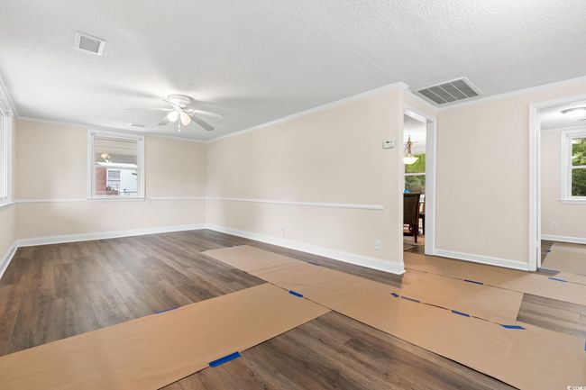 Unfurnished room featuring a ceiling fan, a textured ceiling, wood finished floors, crown molding, and baseboards | Image 18