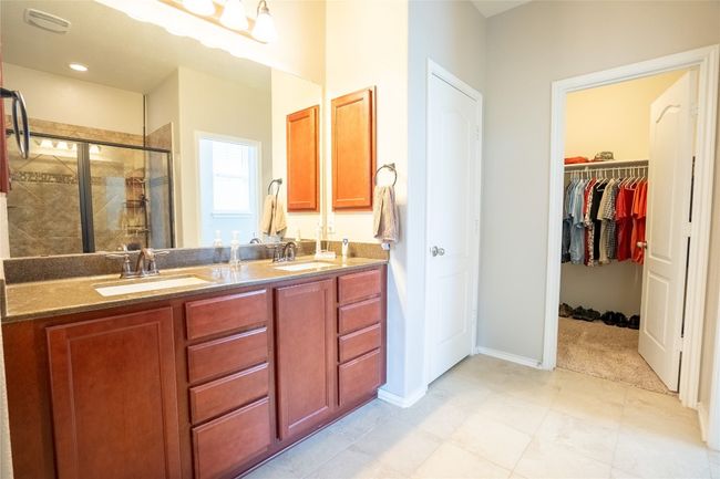 Full bathroom with a stall shower, double vanity, and a walk in closet | Image 16