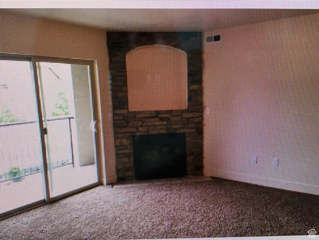 Unfurnished living room featuring a fireplace and carpet flooring | Image 5
