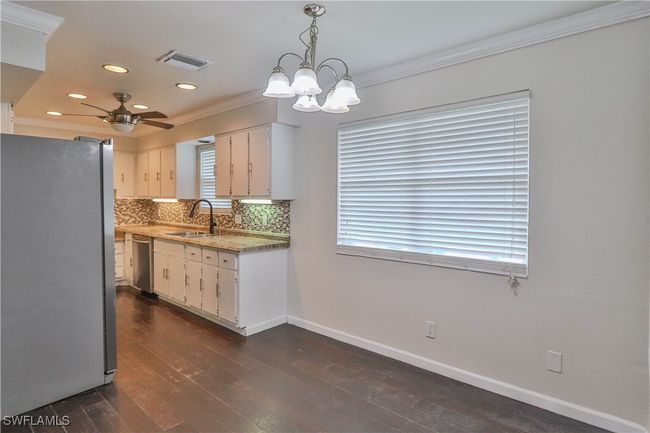 Kitchen with appliances with stainless steel finishes, a sink, ornamental molding, recessed lighting, and decorative backsplash | Image 21