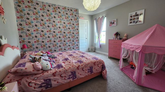 carpeted bedroom featuring a chandelier and baseboards | Image 19
