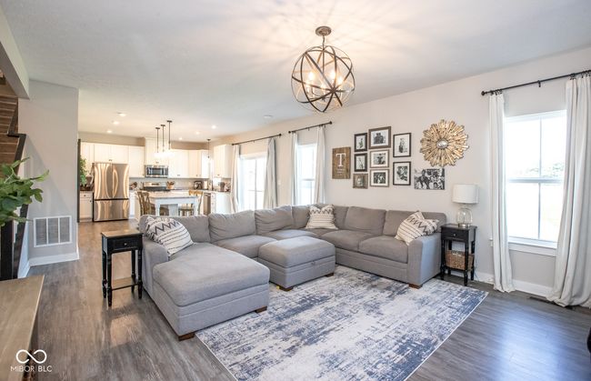 living room with dark wood-style flooring, a chandelier, and recessed lighting | Image 11