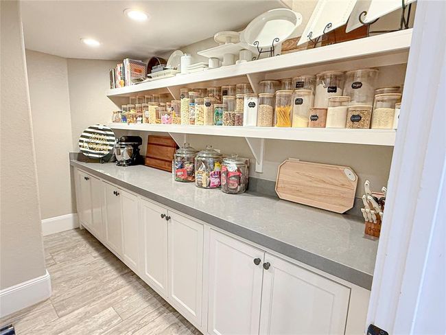 The pantry features beautiful quartz countertops, complete with outlets to create an additional prep station—perfect for entertaining. Whether you're prepping appetizers or assembling drinks, this space offers both functionality and style, allowing you to stay organized and efficient while hosting guests. It's the ideal blend of convenience and elegance for any home entertainer. | Image 33