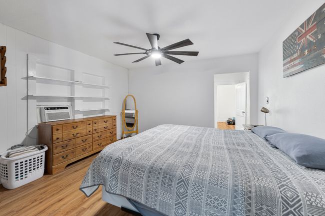 Bedroom with cooling unit, a ceiling fan, and wood finished floors | Image 16