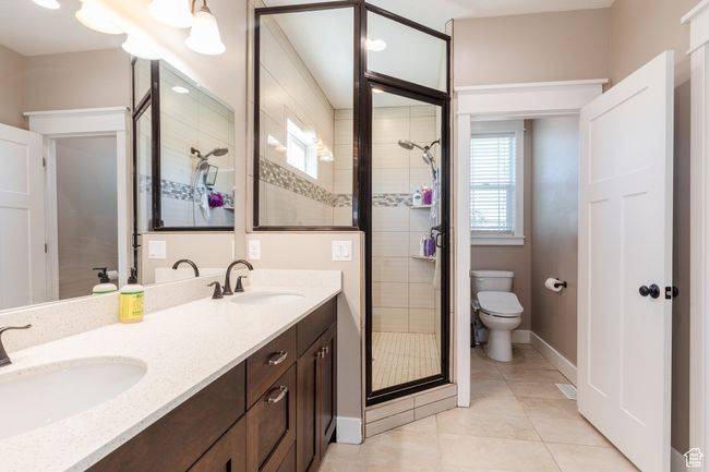Bathroom with a stall shower, tile patterned flooring, and double vanity | Image 26
