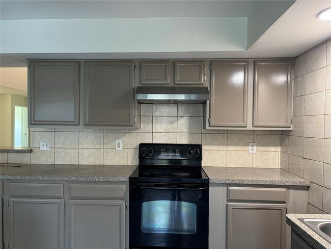 Kitchen featuring black electric range oven, gray cabinetry, and under cabinet range hood | Image 6