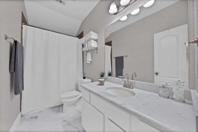 Bathroom featuring vanity, marble finish floors, toilet, and a shower with curtain | Image 39