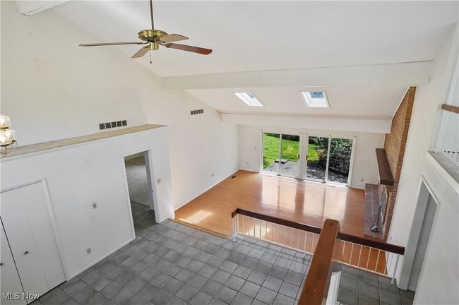 Unfurnished living room with beamed ceiling, visible vents, and high vaulted ceiling | Image 26