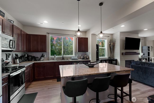 Open kitchen with granite topped island for cooking and socializing. | Image 6