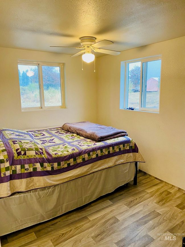 Bedroom featuring wood finished floors, ceiling fan, and a textured ceiling | Image 17