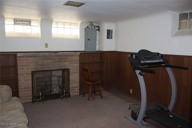 Exercise area with a wainscoted wall, electric panel, and wood walls | Image 16