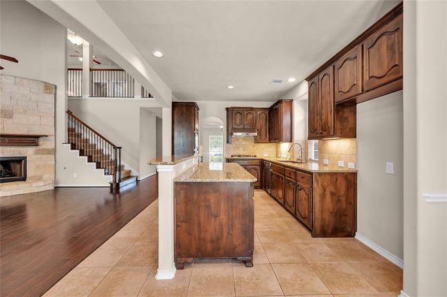 Spacious kitchen featuring elegant wood cabinets and a high-end gas range, perfect for culinary enthusiasts. | Image 10