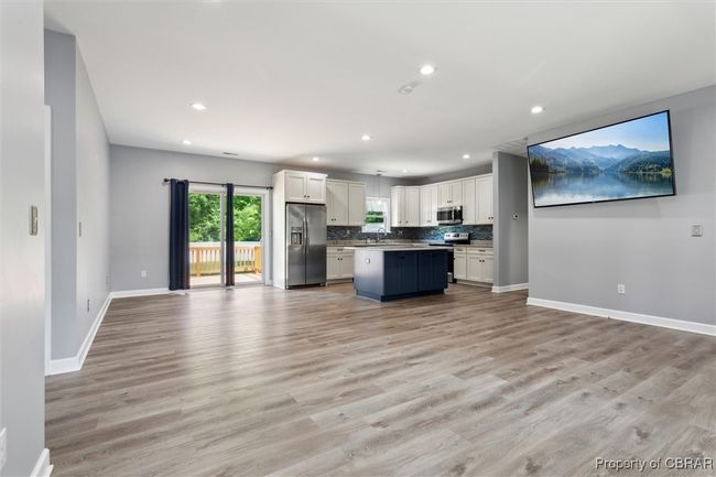 Kitchen featuring stainless steel appliances, open floor plan, white cabinetry, baseboards, and recessed lighting | Image 11