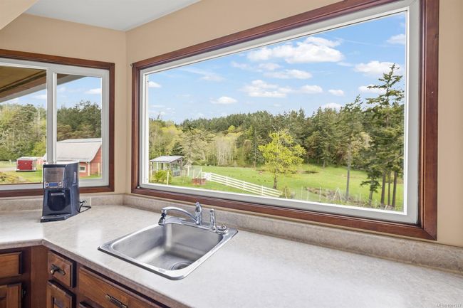 Kitchen with a sink and light countertops | Image 11