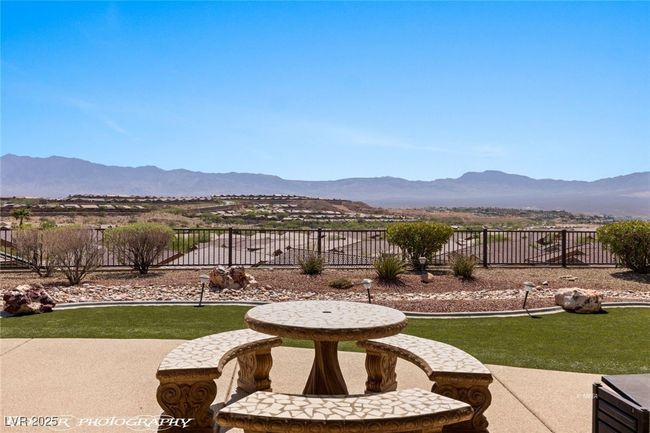 View of yard with a patio area, a mountain view, and fence | Image 64